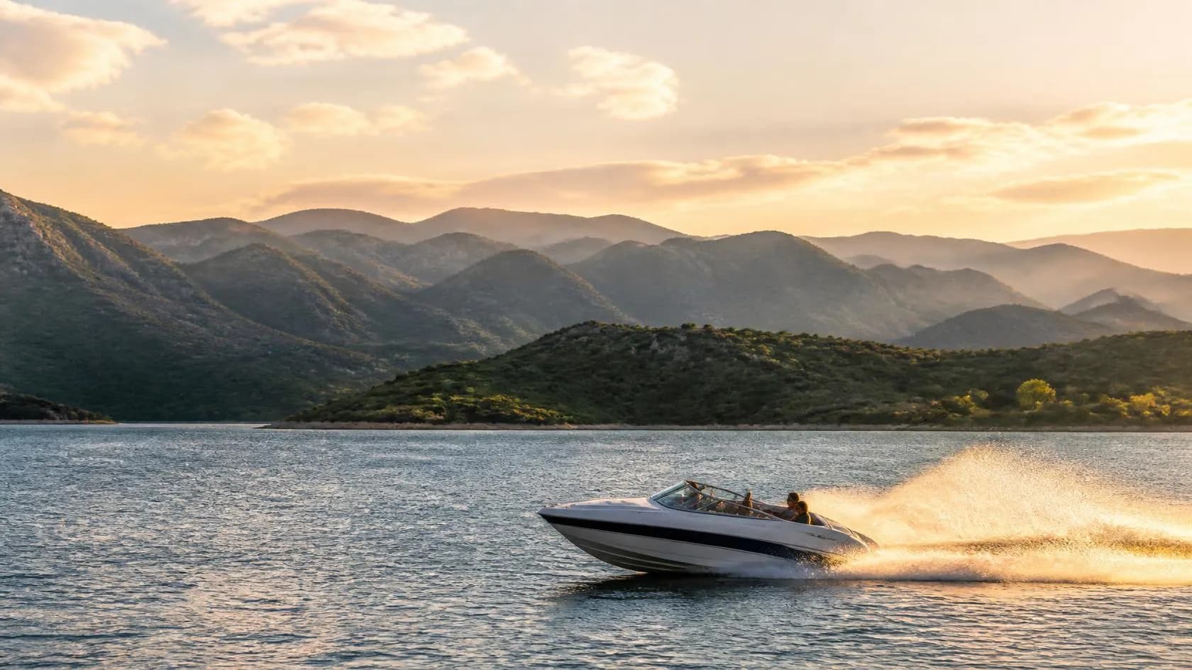 Una lancha navegando al atardecer sobre un lago de las sierras de Córdoba