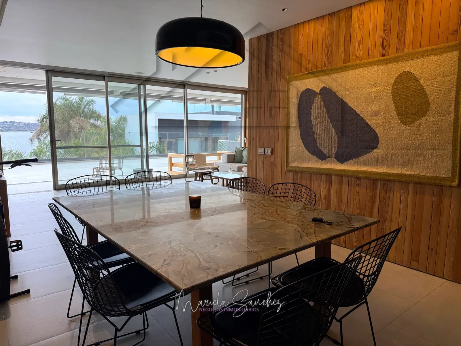 Comedor del departamento con revestimiento de madera y lámpara colgante